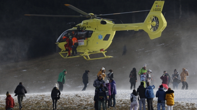 A helicopter carrying Austria's Marco Schwarz, partially seen at center at the helicopter's open door, lands at the finish area after Schwarz crashed during an alpine ski, men's World Cup downhill race, in Bormio, Italy, Thursday, Dec. 28, 2023. (AP Photo/Alessandro Trovati)