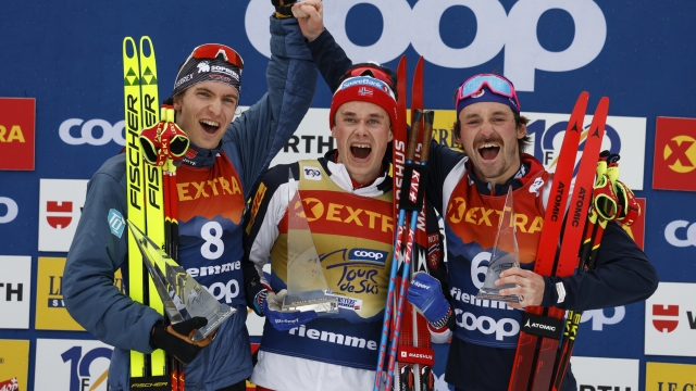 Norway's Harald Oestberg Amundsen, centre, winner of the Tour de Ski overall trophy, poses with second placed Germany's Friedrich Moch, left, and third placed France's Hugo Lapalus, in Val di Fiemme, Italy, Sunday, Jan. 7, 2024. (AP Photo/Alessandro Trovati)
