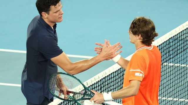 Australia's Alex De Minaur (R) shakes hands with Canada's Milos Raonic after their men's singles match on day two of the Australian Open tennis tournament in Melbourne on January 15, 2024. (Photo by David GRAY / AFP) / -- IMAGE RESTRICTED TO EDITORIAL USE - STRICTLY NO COMMERCIAL USE --