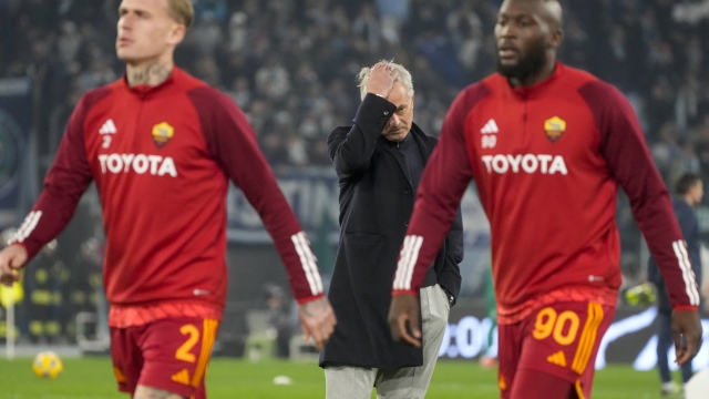 Roma's Romelu Lukaku, right and Rick Karsdorp walks by head coach Jose Mourinho during the warm up ahead of the quarterfinal Italian Cup soccer match between Lazio and Roma at Rome's Olympic Stadium, Wednesday, Jan. 10, 2024. (AP Photo/Gregorio Borgia)