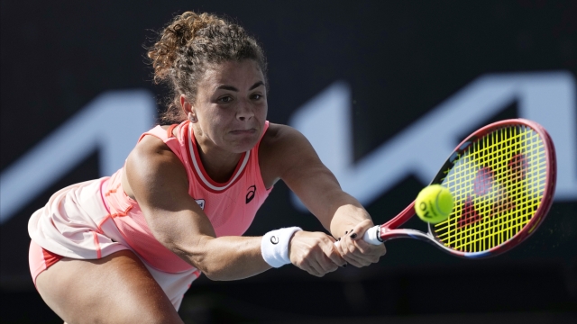Jasmine Paolini of Italy plays a backhand return to Tatjana Maria of Germany during their second round match at the Australian Open tennis championships at Melbourne Park, Melbourne, Australia, Thursday, Jan. 18, 2024. (AP Photo/Alessandra Tarantino)