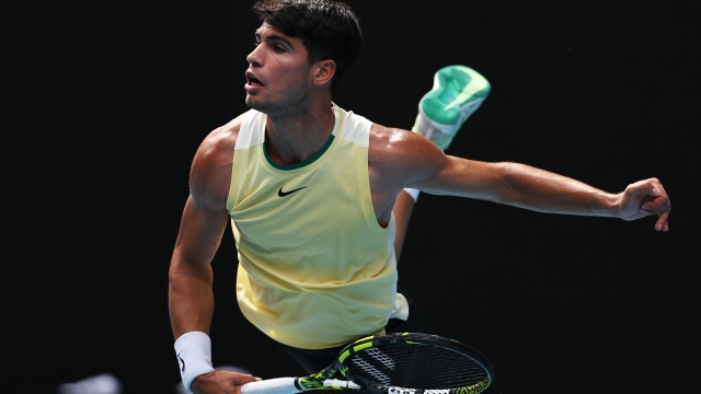 MELBOURNE, AUSTRALIA - JANUARY 20: Carlos Alcaraz of Spain serves in their round three singles match against Juncheng Shang of China during the 2024 Australian Open at Melbourne Park on January 20, 2024 in Melbourne, Australia. (Photo by Cameron Spencer/Getty Images)