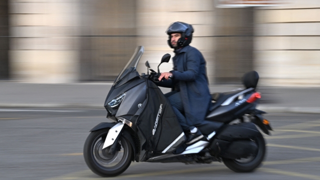 A man rides a petrol scooter in Concorde square in central Paris on November 29, 2023. (Photo by MIGUEL MEDINA / AFP)