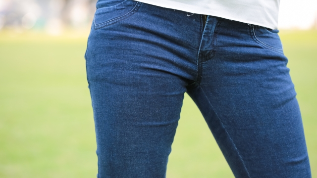 Closeup photo of Women wear blue jeans on green background