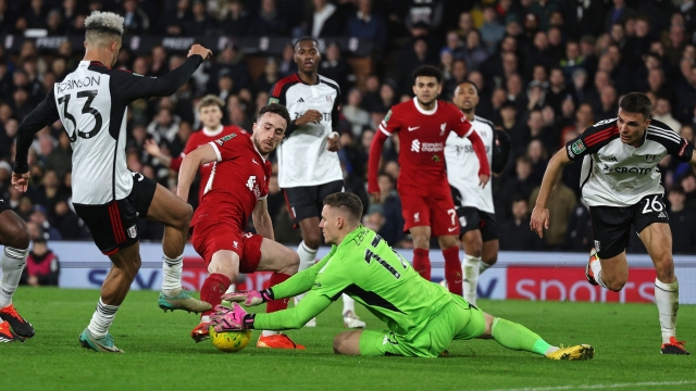 Fulham's German goalkeeper #17 Bernd Leno saves from the feet of Liverpool's Portuguese striker #20 Diogo Jota during the English League Cup demi-final second leg football match between Fulham and Liverpool at Craven Cottage stadium, in London, on January 24, 2024. (Photo by Adrian DENNIS / AFP) / RESTRICTED TO EDITORIAL USE. No use with unauthorized audio, video, data, fixture lists, club/league logos or 'live' services. Online in-match use limited to 120 images. An additional 40 images may be used in extra time. No video emulation. Social media in-match use limited to 120 images. An additional 40 images may be used in extra time. No use in betting publications, games or single club/league/player publications. /