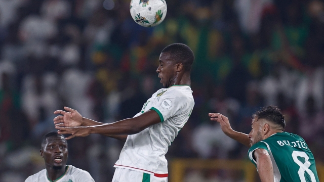 Mauritania's defender #12 Bakari Camara (C) heads the ball as Algeria's forward #8 Youcef Belaili reacts during the Africa Cup of Nations (CAN) 2024 group D football match between Mauritania and Algeria at Stade de la Paix in Bouake on January 23, 2024. (Photo by KENZO TRIBOUILLARD / AFP)