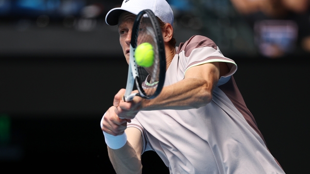 MELBOURNE, AUSTRALIA - JANUARY 26: Jannik Sinner of Italy plays a backhand in their Semifinal singles match against Novak Djokovic of Serbia during the 2024 Australian Open at Melbourne Park on January 26, 2024 in Melbourne, Australia. (Photo by Daniel Pockett/Getty Images)