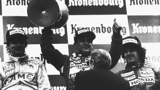 Brazilian driver Ayrton Senna, center, holds his winner's cup aloft on the victory stand after he won the Formula One, San Marino Grand Prix in Imola, Italy, May 1, 1988. Also on the stand are Nelson Pique of Brazil, left, who came in Third, and Senna's teammate Alain Prost, of France, who came in second. (AP Photo)