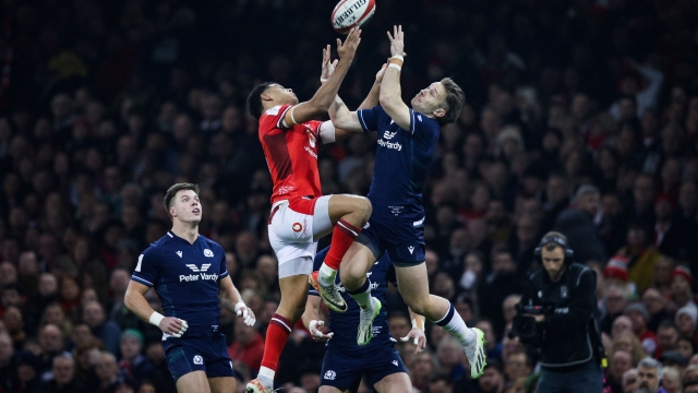 TOPSHOT - Wales' wing Josh Adams (L) and Scotland's full-back Kyle Rowe jump for the ball during the Six Nations international rugby union match between Wales and Scotland at the Principality Stadium in Cardiff, south Wales, on February 3, 2024. (Photo by Adrian DENNIS / AFP) / RESTRICTED TO EDITORIAL USE. Use in books subject to Welsh Rugby Union (WRU) approval.