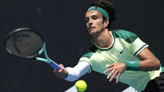 Lorenzo Musetti of Italy plays a forehand return to Benjamin Bonzi of France during their first round match at the Australian Open tennis championships at Melbourne Park, Melbourne, Australia, Monday, Jan. 15, 2024. (AP Photo/Alessandra Tarantino)