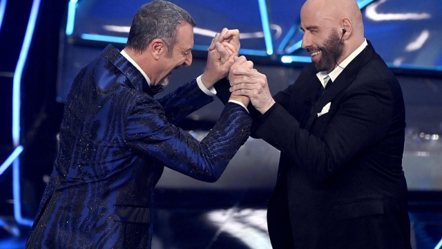 Sanremo Festival host and artistic director Amadeus (L) and US actor John Travolta on stage at the Ariston theatre during the 74th Sanremo Italian Song Festival in Sanremo, Italy, 07 February 2024. The music festival runs from 06 to 10 February 2024.   ANSA/RICCARDO ANTIMIANI