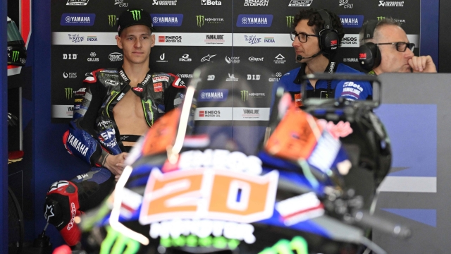 Monster Energy Yamaha's French rider Fabio Quartararo (L) sits inside his team garage during the first day of the pre-season MotoGP test at the Sepang International Circuit in Sepang on February 6, 2024. (Photo by Mohd RASFAN / AFP)
