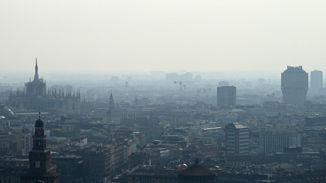TOPSHOT - A blanket of smog covers Milan's skyline with the Duomo (L) and the Velasca tower (R) on February 21, 2024 in Milan. Gas-guzzling cars were banned from roads Tuesday in Milan and eight other cities across Lombardy after the northern Italian industrial region registered high levels of particle pollution dangerous for health. (Photo by GABRIEL BOUYS / AFP)