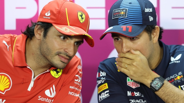 epaselect epa11169680 Scuderia Ferrari driver Carlos Sainz Jr. of Spain (L) and Red Bull Racing driver Sergio Perez of Mexico (R) talk in whispers while they attend a press conference during the pre-season testing for the 2024 Formula One season at the Bahrain International Circuit in Sakhir, Bahrain, 21 February 2024.  EPA/ALI HAIDER