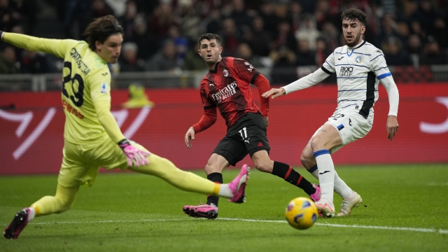 AC Milan's Christian Pulisic, center, attempts a score during a Serie A soccer match between AC Milan and Atalanta at the San Siro stadium in Milan, Italy, Sunday, Feb. 25, 2024. (AP Photo/Antonio Calanni)