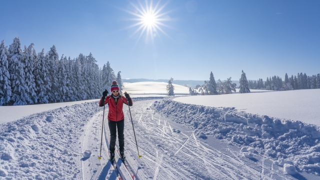 beautiful active senior woman cross-country skiing in fresh fallen powder snow in the Allgau alps near Immenstadt, Bavaria, Germany