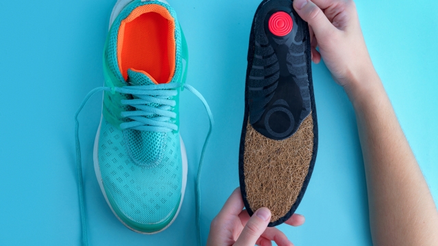 Orthopedic insoles for sneakers on a blue background. Prevention and treatment of flat feet. Foot care and wearing comfortable sports shoes