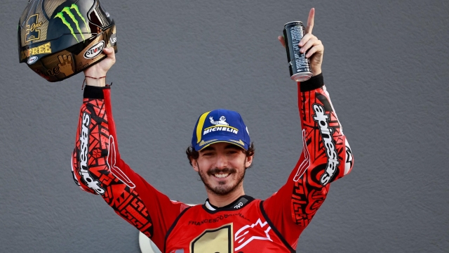 Ducati Italian rider Francesco Bagnaia celebrates winning the MotoGP Valencia Grand Prix at the Ricardo Tormo racetrack in Cheste, on November 26, 2023. Italy's Francesco Bagnaia enjoyed a dream day as he retained his MotoGP world title and crowned it with victory in the final race of the season in Valencia today. The 26-year-old Ducati rider had been assured of the championship when his sole rival Jorge Martin crashed early in the race. (Photo by JOSE JORDAN / AFP)