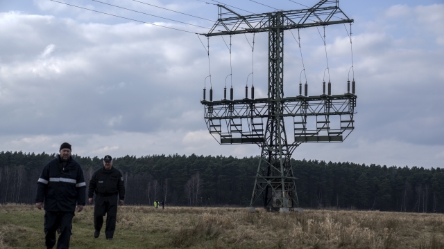 Police officers work next to a damaged pylon near the Tesla Gigafactory for electric cars in Gruenheide near Berlin, Germany, Tuesday, March 5, 2024. Production at Tesla's electric vehicle plant in Germany came to a standstill and workers were evacuated after a power outage that officials suspect was caused by arson. The interior ministry in the state of Brandenburg says unidentified people are suspected of deliberately setting fire to a high-voltage transmission line on a power pylon. (AP Photo/Ebrahim Noroozi)