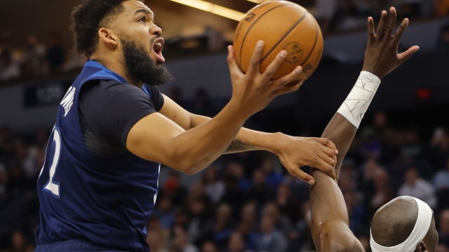 Minnesota Timberwolves forward Karl-Anthony Towns, left, goes to the basket against the Portland Trail Blazers in the first quarter of an NBA basketball game Monday, March 4, 2024, in Minneapolis. (AP Photo/Bruce Kluckhohn)