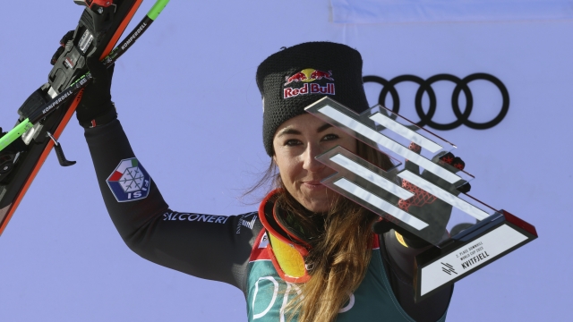 Italy's Sofia Goggia celebrates on the podium after taking second place in an alpine ski, World Cup women's downhill race, in Kvitfjell, Norway, Saturday, March 4, 2023. (AP Photo/Marco Trovati)
