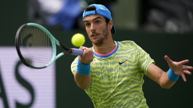 Lorenzo Musetti, of Italy, returns a shot against Holger Rune, of Denmark, at the BNP Paribas Open tennis tournament in Indian Wells, Calif., Monday, March 11, 2024. (AP Photo/Ryan Sun)