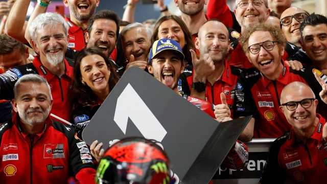 Ducati Lenovo Team Italian rider Francesco Bagnaia (C) poses for a group photograph along with his team members after winning the Qatar MotoGP Grand Prix at the Lusail International Circuit in Lusail, north of Doha on March 10, 2024. (Photo by KARIM JAAFAR / AFP)