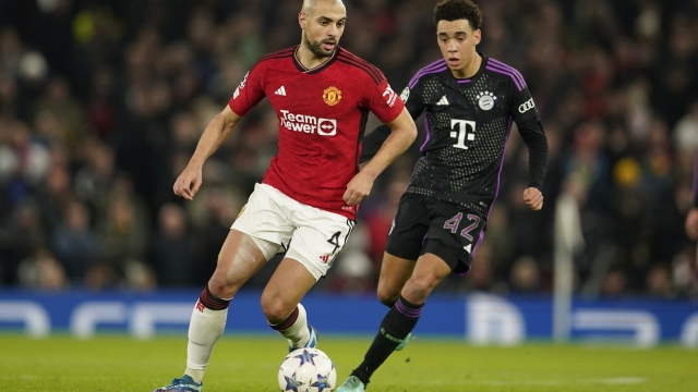 Manchester United's Sofyan Amrabat, left, and Bayern's Jamal Musiala vie for the ball during the group A Champions League soccer match between Manchester United and Bayern Munich at the Old Trafford stadium in Manchester, England, Tuesday, Dec. 12, 2023. (AP Photo/Dave Thompson)