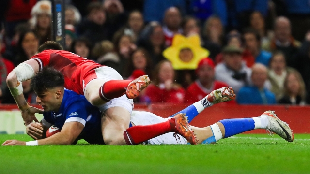 Italy's full-back Lorenzo Pani (under L) dives across the line to score a try during the Six Nations international rugby union match between Wales and Italy at the Principality Stadium in Cardiff, south Wales, on March 16, 2024. (Photo by Geoff Caddick / AFP) / RESTRICTED TO EDITORIAL USE. Use in books subject to Welsh Rugby Union (WRU) approval.