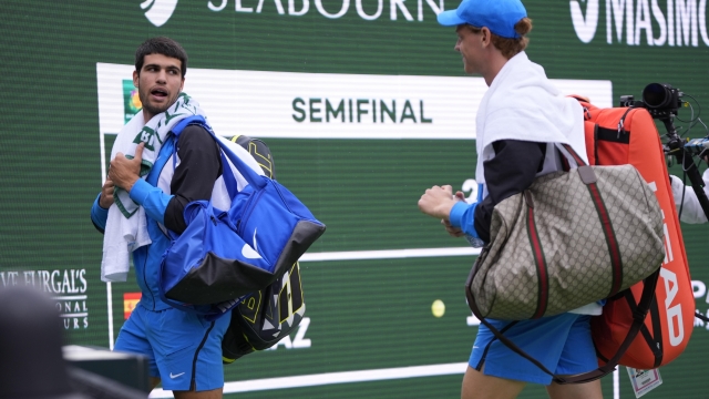 Carlos Alcaraz, of Spain, left, and Jannik Sinner, of Italy, leave the court during a rain delay in their semifinal match at the BNP Paribas Open tennis tournament, Saturday, March 16, 2024, in Indian Wells, Calif. (AP Photo/Mark J. Terrill)
