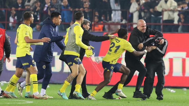 epa11226896 A Trabzonspor fan (R) attacks Fenerbahce players after the Super League match between Trabzonspor and Fenerbahce in Trabzon, Turkey, 17 March 2024. After Fenerbahce won the match 3-2 against Trabzonspor fans entered the field and began chasing away Fenerbahce players.  EPA/STR