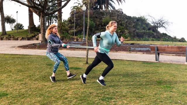 Women doing work out at park, strengthening running exercise - two beautiful young women in Porto training together on a cloudy day - outdoor activities and sport