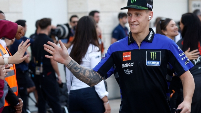 Monster Energy Yamaha MotoGP French rider Fabio Quartararo gestures to his fans during the 'MotoGP VIP Village Pit Lane Walk' ahead of the Qatar MotoGP Grand Prix at the Lusail International Circuit in Lusail, north of Doha on March 10, 2024. (Photo by KARIM JAAFAR / AFP)