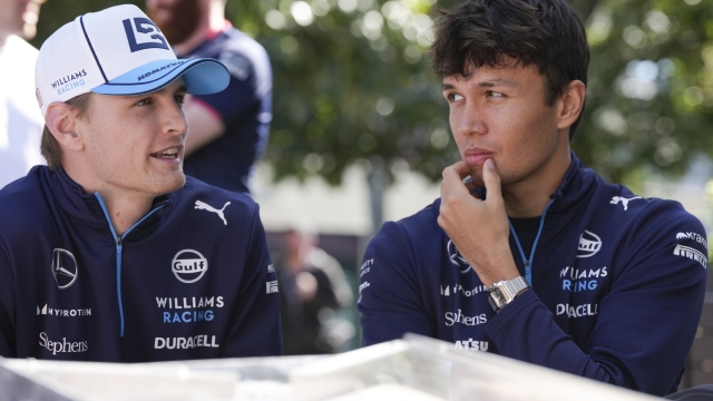 Williams driver Logan Sargeant, left, of the US and teammate Alexander Albon of Thailand react as they sit outside their team garage ahead of the Australian Formula One Grand Prix at Albert Park, Melbourne, Australia, Thursday, March 21, 2024. (AP Photo/Asanka Brendon Ratnayake)