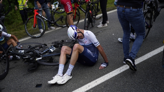 Britain's Chris Froome lays on the road after crashing during the first stage of the Tour de France cycling race over 197.8 kilometers (122.9 miles) with start in Brest and finish in Landerneau, France, Saturday, June 26, 2021. (AP Photo/Daniel Cole)