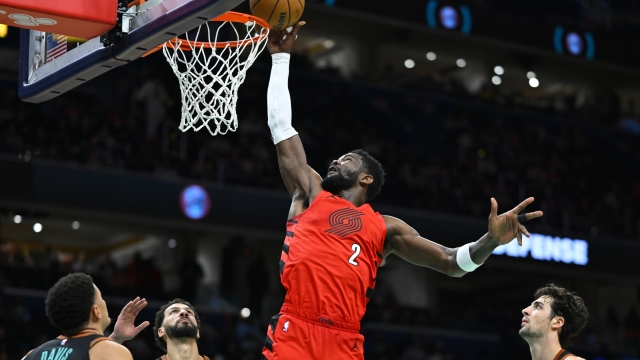 Portland Trail Blazers center Deandre Ayton, (2) scores against Washington Wizards guard Johnny Davis, left, forward Anthony Gill, second from left, and forward Deni Avdija, right, during the second half of an NBA basketball game Friday, April 5, 2024, in Washington. (AP Photo/John McDonnell)