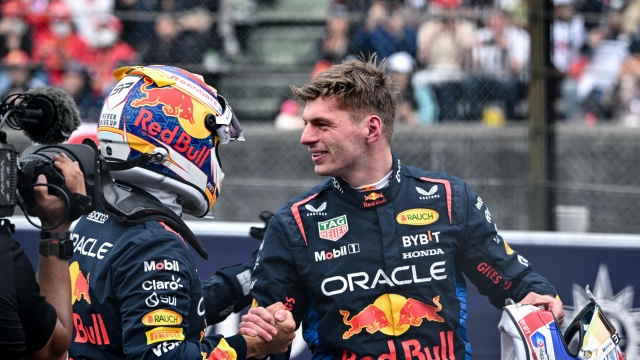 Pole position qualifier Red Bull Racing's Dutch driver Max Verstappen (R) reacts with second-placed qualifier Red Bull Racing's Mexican driver Sergio Perez after the qualifying session for the Formula One Japanese Grand Prix race at the Suzuka circuit in Suzuka, Mie prefecture on April 6, 2024. (Photo by Philip FONG / AFP)