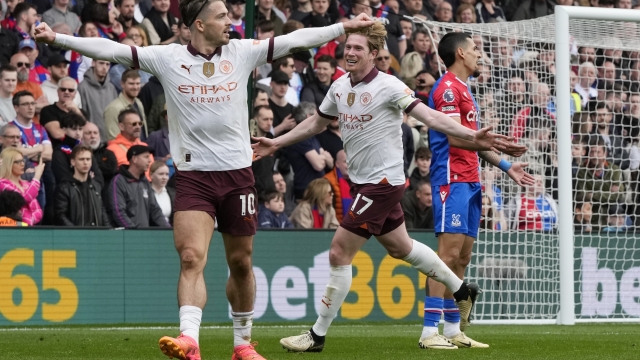 Manchester City's Kevin De Bruyne, centre, celebrates with Jack Grealish, left, after scoring his side's fourth goal during the English Premier League soccer match between Crystal Palace and Manchester City at Selhurst Park stadium in London, Saturday, April 6, 2024.(AP Photo/Frank Augstein)