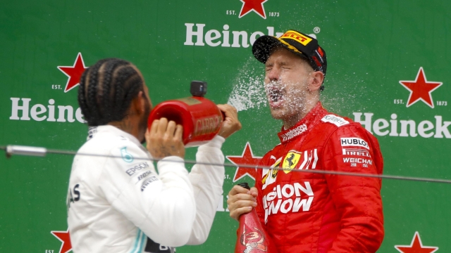 epa07505525 Winner British Formula One driver Lewis Hamilton (L) of Mercedes AMG GP sprays champagne on third placed German Formula One driver Sebastian Vettel of Scuderia Ferrari at the end of the Chinese Formula One Grand Prix at the Shanghai International circuit in Shanghai, China, 14 April 2019.  EPA/DIEGO AZUBEL