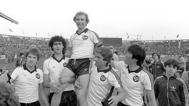 FILED - 02 May 1981, Baden-Württemberg, Stuttgart: Eintracht Frankfurt striker and captain Bernd Hölzenbein (above) is carried on the shoulders of his teammates Bernd Nickel (l-r), Bruno Pezzey, Werner Lorant and Bum-Kun Cha at the end of the match. Eintracht Frankfurt won the DFB Cup final against 1. FC Kaiserslautern 3:1 in front of 71,000 spectators in Stuttgart's Neckarstadion, securing the cup for the third time. Hölzenbein died at the age of 78. Photo: picture alliance / dpa (Photo by ROLAND WITSCHEL / DPA / dpa Picture-Alliance via AFP)