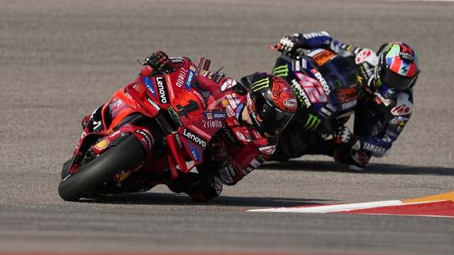 MotoGP rider Francesco Bagnaia (1), of Italy, and Alex Rins (42), of Spain, steer through a turn during a practice session for the MotoGP Grand Prix of the Americas motorcycle race at the Circuit of the Americas, Saturday, April 13, 2023, in Austin, Texas. (AP Photo/Eric Gay)