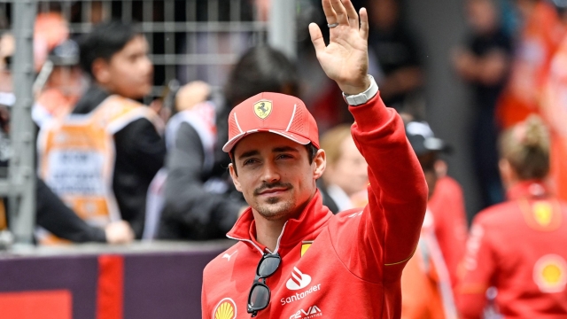 Ferrari's Monegasque driver Charles Leclerc waves as he arrives ahead of the Formula One Chinese Grand Prix race at the Shanghai International Circuit in Shanghai on April 21, 2024. (Photo by PEDRO PARDO / AFP)