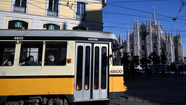 People commute on a tram near the Duomo Cathedral in Milan, on February 13, 2024. (Photo by GABRIEL BOUYS / AFP)