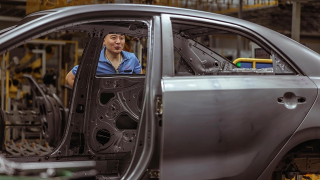 epa10195087 An employee works during an organised media tour to Dongfeng Yueda Kia Factory, in Yancheng, Jiangsu province, China, 20 September 2022. Dongfeng Yueda Kia Factory was put into production in Yancheng, in early 2014, with an annual production capacity of 450,000 vehicles per year. It has a fully automatic production line composed of stamping, welding, painting, final assembly and engine workshops.  EPA/ALEX PLAVEVSKI