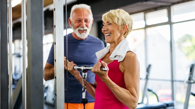 Happy senior people doing exercises in fitness gym to stay fit. People sport concept.