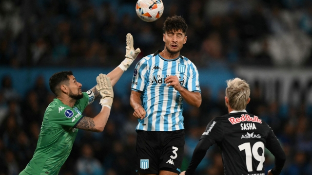 Racing's Chilean goalkeeper Gabriel Arias (L) and defender Marco Di Cesare try to clear the ball during the Copa Sudamericana group stage first leg match between Argentina's Racing and Brazil's Red Bull Bragantino at the El Cilindro Stadium in Buenos Aires on April 10, 2024. (Photo by Luis ROBAYO / AFP)