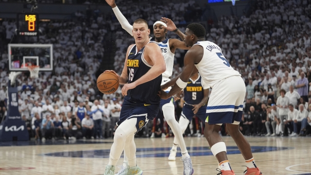 Denver Nuggets center Nikola Jokic, left, works toward the basket as Minnesota Timberwolves forward Jaden McDaniel, center, and guard Anthony Edwards defend during the second half of Game 4 of an NBA basketball second-round playoff series, Sunday, May 12, 2024, in Minneapolis. (AP Photo/Abbie Parr)