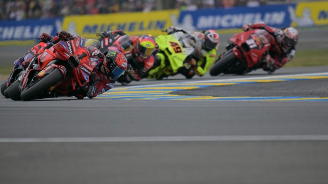 Ducati Lenovo Team's Italian rider Francesco Bagnaia (L) and the pack compete during the French MotoGP Grand Prix race at the Bugatti circuit in Le Mans, northwestern France, on May 12, 2024. (Photo by LOU BENOIST / AFP)