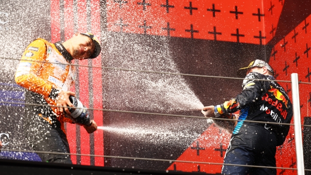 IMOLA, ITALY - MAY 19: Race winner Max Verstappen of the Netherlands and Oracle Red Bull Racing and Second placed Lando Norris of Great Britain and McLaren celebrate on the podium during the F1 Grand Prix of Emilia-Romagna at Autodromo Enzo e Dino Ferrari Circuit on May 19, 2024 in Imola, Italy. (Photo by Mark Thompson/Getty Images)