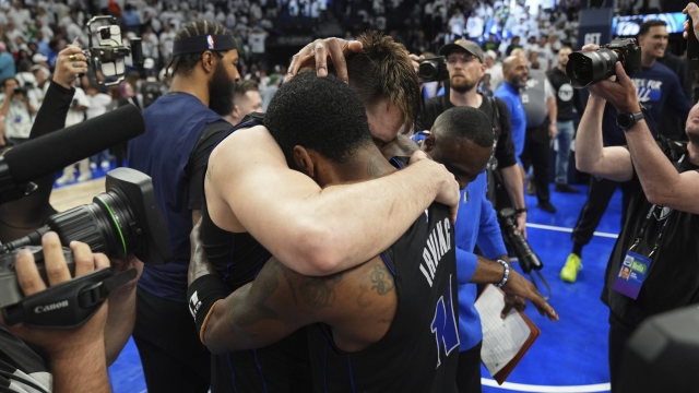 Dallas Mavericks guard Kyrie Irving, right, and guard Luka Doncic embrace after defeating the Minnesota Timberwolves in Game 2 of the NBA basketball Western Conference finals, Friday, May 24, 2024, in Minneapolis. (AP Photo/Abbie Parr)